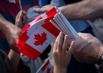 A boy reaches for a Canadian flag on Canada Day in Vancouver, Monday, July 1, 2024. THE CANADIAN PRESS/Ethan Cairns