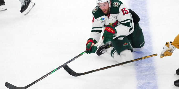 Apr 29, 2025; Las Vegas, Nevada, USA; Minnesota Wild right wing Justin Brazeau (15) plays the puck against the Vegas Golden Knights during the third period of game five of the first round of the 2025 Stanley Cup Playoffs at T-Mobile Arena. Mandatory Credit: Stephen R. Sylvanie-Imagn Images