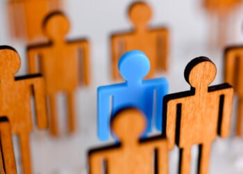 Little plastic blue toy figure stand out from unit crowd line closeup. One worker against odd hr job shift head hunter rare disease unit dismissal retire lgbt media virus epidemic success concept