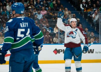 Nov 9, 2025; Vancouver, British Columbia, CAN; Vancouver Canucks forward Aatu Raty (54) and forward Kiefer Sherwood (44) react as Colorado Avalanche forward Nathan MacKinnon (29) celebrates his second goal of the game in the first period at Rogers Arena. Mandatory Credit: Bob Frid-Imagn Images