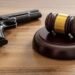Gavel and handgun on a wooden table representing Canada’s gun buyback program