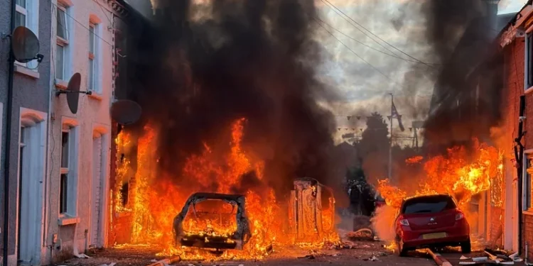 Police officers facing rioters amid ongoing Belfast riots following stabbing attack